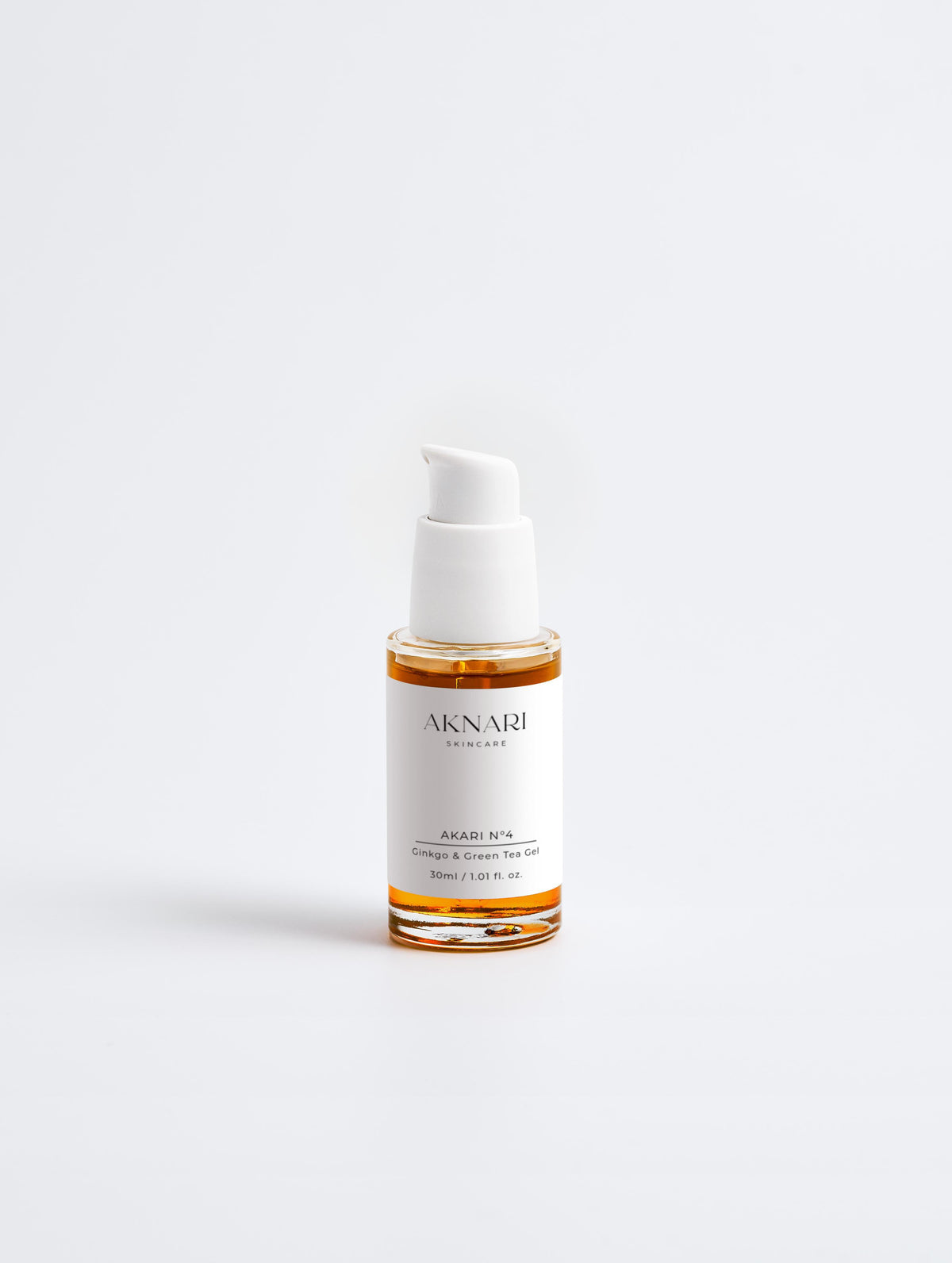 Glass dropper bottle with orange gel and white head and label in front of white background.