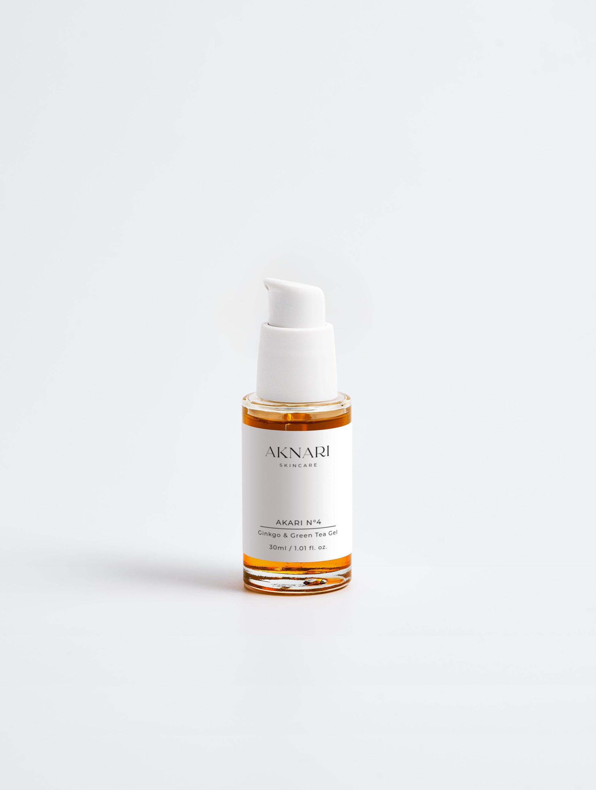 Glass dropper bottle with orange gel and white head and label in front of white background.